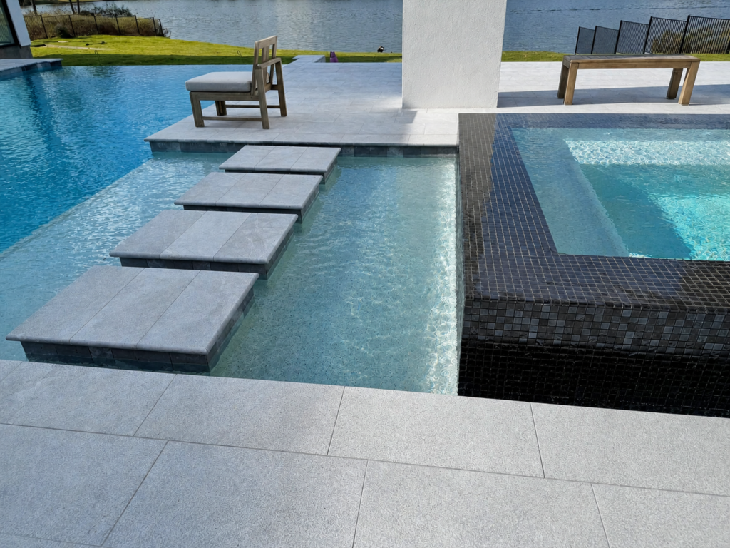 Raised spa with stepping pads and dark tile detail in a custom pool in The Woodlands, Texas